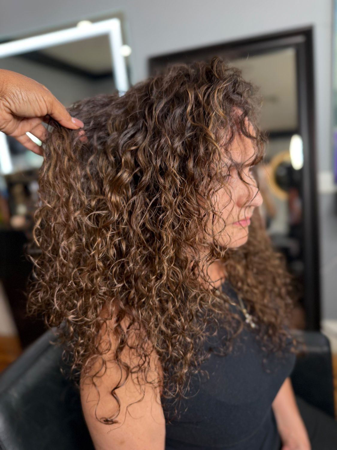 Cabello rizado con balayage y mechones caramelo