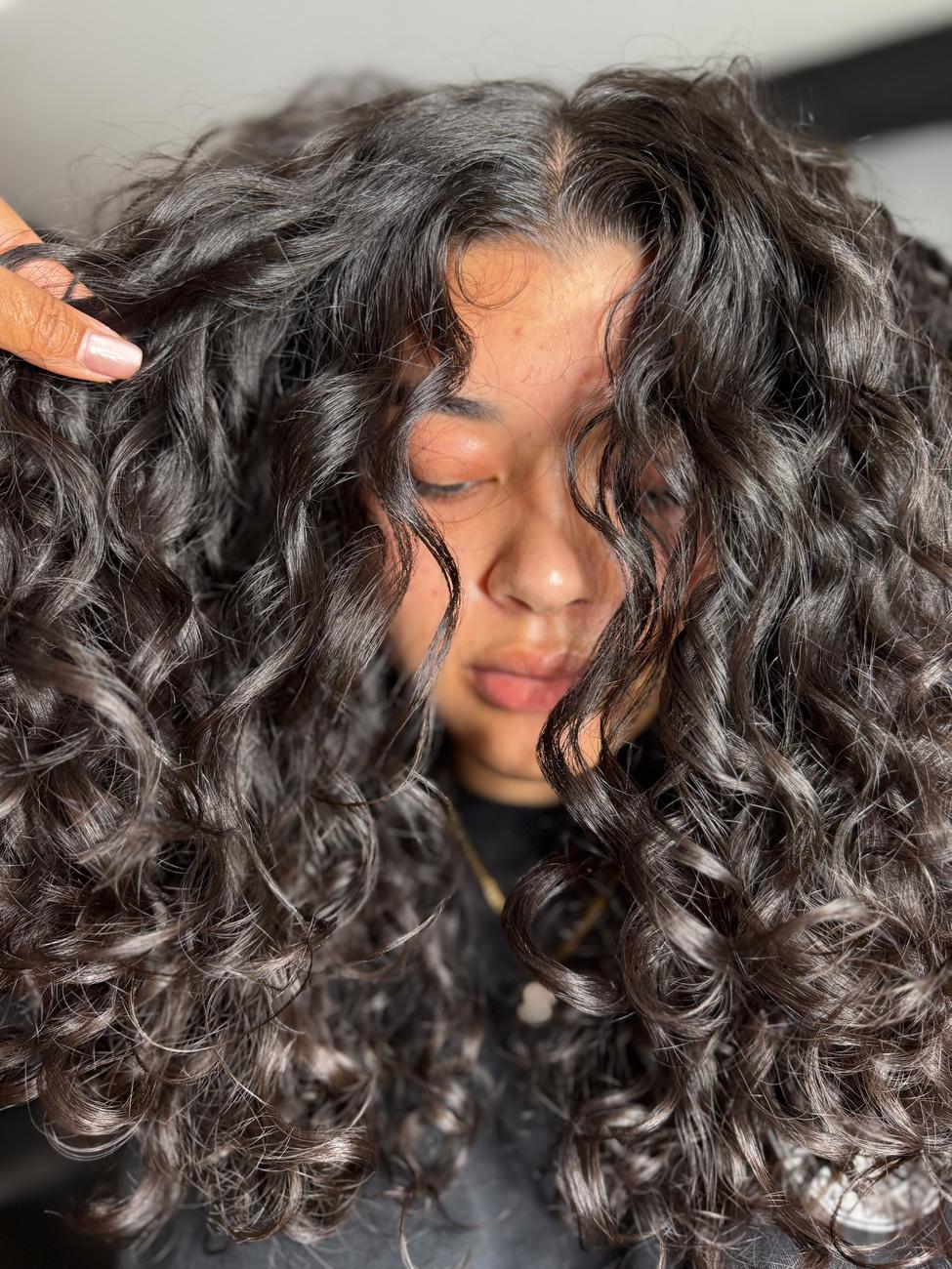 Cabello rizado con textura definida y mechones plateados